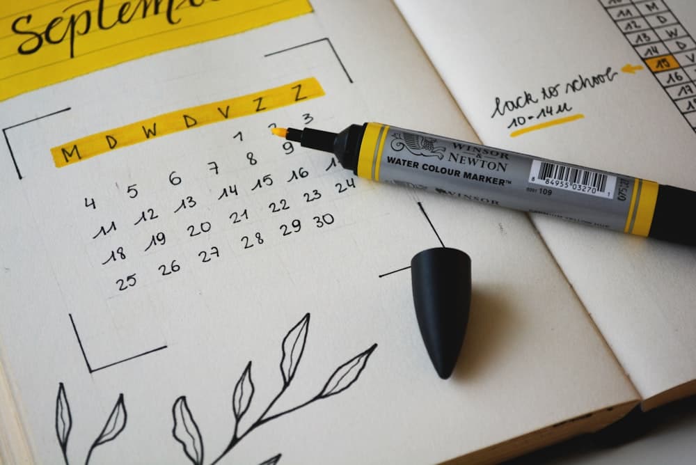 Agenda papier ouvert sur le mois de septembre avec un surligneur jaune